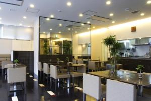 仙台Dormy Inn Sendai Station Natural Hot Springs的一间带桌椅和镜子的用餐室