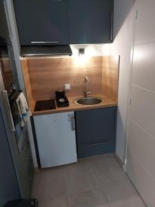 een kleine keuken met een wastafel en een fornuis bij Studio neuf à louer à Dinard 3 nuits minimum in Dinard