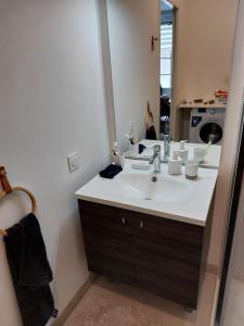 een badkamer met een wastafel en een grote spiegel bij Studio neuf à louer à Dinard 3 nuits minimum in Dinard