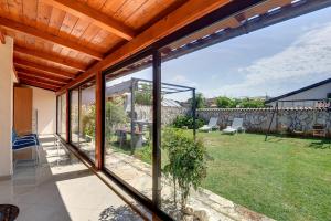 a glass extension to a house with a garden at House Jasminka in Medulin