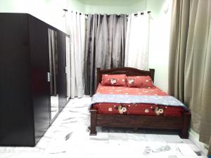 a bedroom with a bed with red sheets and pillows at D' SHAM Homestay, Mslim Only in Kulim