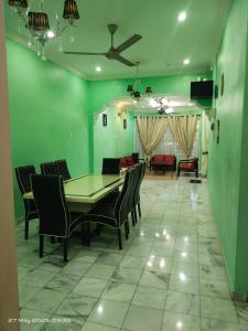 a dining room with a table and chairs and a couch at D' SHAM Homestay, Mslim Only in Kulim
