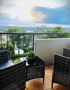 a balcony with two chairs and a table with a view at Mosman Views, 2bed, Parking, 15min Walk to Beach in Sydney