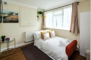 1 dormitorio con cama blanca y ventana en Where Style & Convenience Combine- Photo ID & Deposit Required en Londres