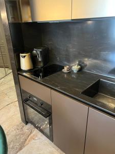 a kitchen with a black counter top and a sink at Apart Elena Arcadia Sea View in Odesa