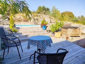 un patio con mesa, sillas y piscina en Quiet and comfy with swimming pool, en Onsala