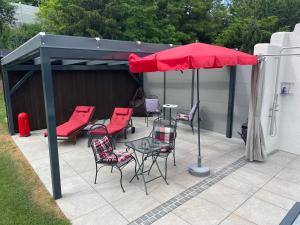 eine Terrasse mit einem Tisch, Stühlen und einem Sonnenschirm in der Unterkunft Apartment Nürnberg in Nürnberg