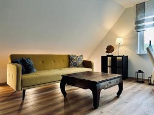ein Wohnzimmer mit einem Sofa und einem Couchtisch in der Unterkunft Moderne Ferienwohnung Zweifall in Stolberg
