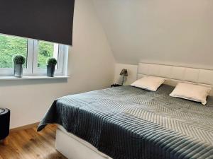 ein Schlafzimmer mit einem großen Bett mit zwei Kissen in der Unterkunft Moderne Ferienwohnung Zweifall in Stolberg