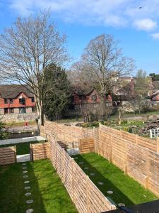 una recinzione di legno in un cortile con erba di House situated on River Itchen a Winchester