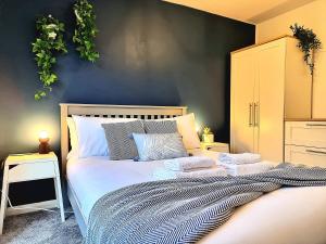 una camera da letto con un grande letto con asciugamani di Large House with Free Parking and Long Stay Offers a Leicester