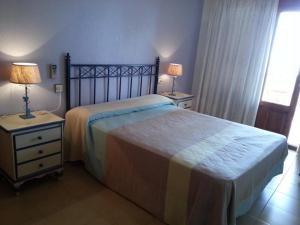 サン・ホセにあるApartamento en la Playa de San José-sjjcのベッドルーム1室(ベッド1台付)、2泊分のスタンド(ランプ付)