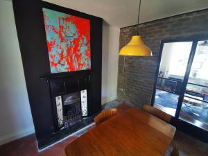 a dining room with a table and a fireplace at Newly Renovated 3 bedroom house in Taibach