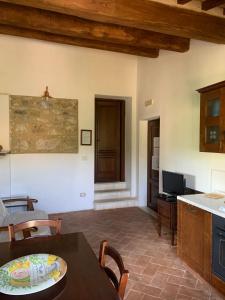 a living room with a table and a kitchen at Podere le Mulina in Castiglione dʼOrcia