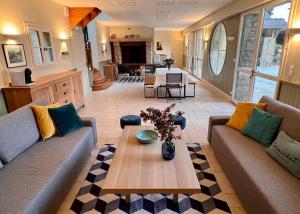 a living room with two couches and a table at Villa en bord de mer 6 personnes, à côte du Château des Tourelles, piscine d'eau de mer in Pornichet