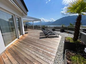 une terrasse en bois avec des bancs sur une maison dans l'établissement Casa Fontanalba App 1111, à Minusio