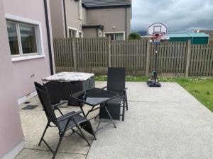 a patio with two chairs and a basketball hoop at Kerry Coastal Hideaway in Fenit