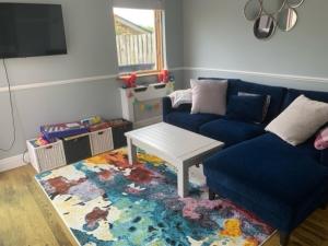 sala de estar con sofá azul y mesa en Kerry Coastal Hideaway en Fenit