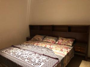 a bedroom with a bed with a wooden headboard and pillows at Three-Bedroom Apartment in Mohandseen in Cairo