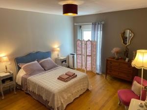 een slaapkamer met een bed, een stoel en een raam bij Maison 1823 - Suites de charme à Garons in Garons