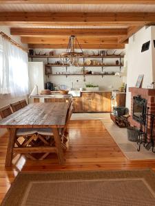 une salle à manger avec une table en bois et une cuisine dans l'établissement Domek nad Śniardwami, à Głodowo