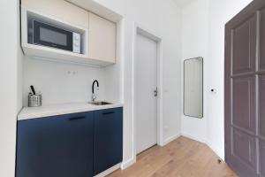 a kitchen with a sink and a tv on the wall at Villa Oliver Budapest in Budapest