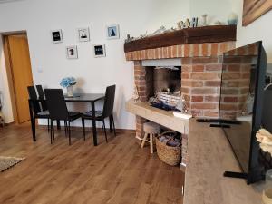 a living room with a table and a brick fireplace at Relax green house in Rovinj