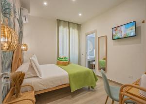 a bedroom with a bed and a tv on a wall at B&B Oasi Rooms in Agropoli