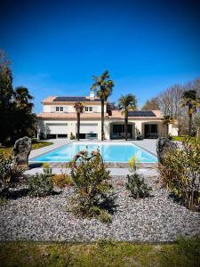 une grande piscine en face d'une maison dans l'établissement LA MAISON CACHEE-BA, à La Teste-de-Buch