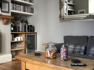 uma sala de estar com uma mesa e um sofá em St Bernards em Newquay