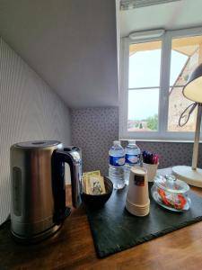 a kitchen counter with a coffee maker on a table at La Maison VH in Mont-de-Marsan