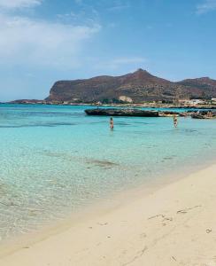 een groep mensen in het water op een strand bij Stabilimento Lido Burrone in Favignana