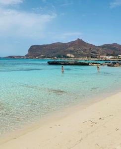 a group of people in the water on a beach at Stabilimento Lido Burrone in Favignana