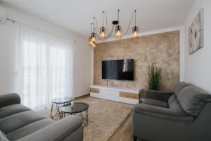 a living room with two couches and a tv at Royal Blue House 3 in Kaštela