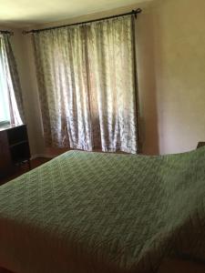 a bedroom with a bed and a window with curtains at "Maroli House" in Vrŭv