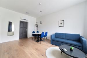 a living room with a blue couch and a table at Villa Oliver Budapest in Budapest
