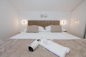 a white bed with a bottle and towels on it at Royal Blue House 3 in Kaštela
