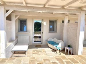 a porch of a house with a couch and a table at Stabilimento Lido Burrone in Favignana