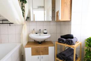 La salle de bains est pourvue d'un lavabo et d'une baignoire. dans l'établissement Infinity Homes - Stylish 3-Bedroom Haven in the Heart of Vienna!, à Vienne