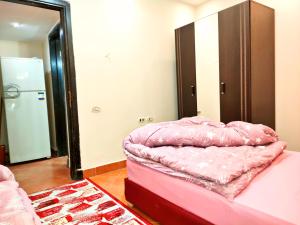 a pink bed in a room with a mirror at شاليه تامر عمر في ابراج بورتو السخنة للعائلات فقط Tamer Omar's Chalet in Porto Elsokhna Towers only Family in Ain Sokhna