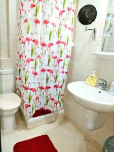 a bathroom with a shower curtain with a toilet and a sink at شاليه تامر عمر في ابراج بورتو السخنة للعائلات فقط Tamer Omar's Chalet in Porto Elsokhna Towers only Family in Ain Sokhna