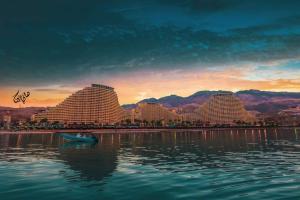 a group of buildings on a body of water with a boat at شاليه تامر عمر في ابراج بورتو السخنة للعائلات فقط Tamer Omar's Chalet in Porto Elsokhna Towers only Family in Ain Sokhna