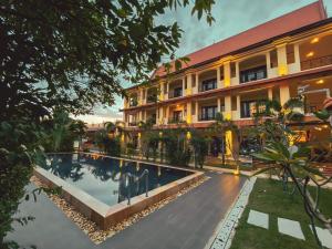 un hotel con piscina frente a un edificio en Savada Angkor Boutique Hotel, en Siem Reap