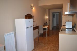 a kitchen with a white refrigerator and a table at Podere San Marco in Bonate di Sopra