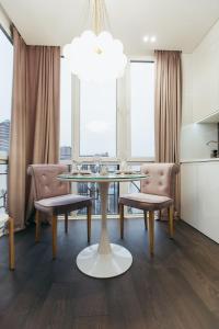 uma sala de jantar com uma mesa de vidro e 2 cadeiras em Atlant luxury VIOLET Apart on Golovna стильні апартаменти поряд з ТЦ ДЕПОТ БЕЗКОНТАКТНЕ ЗАСЕЛЕННЯ em Chernivtsi