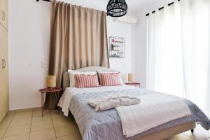 a bedroom with a large bed with pink pillows at Oliva Holiday Homes in Dhiyeliótika +136 photos