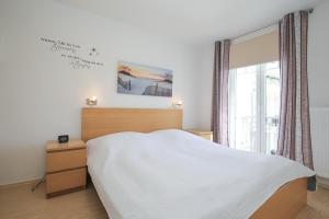 - une chambre avec un lit blanc et une fenêtre dans l'établissement Achtern Diek Wohnung 14, à Boltenhagen