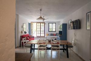 a dining room and living room with a table and chairs at Baccu Mandara Sea View Modern Villa with Parking! in Geremeas