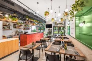 a restaurant with wooden tables and chairs and a green wall at Florin Apart Hotel in Budapest
