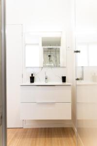een witte badkamer met een wastafel en een spiegel bij Le Tropical - Beau logement centre - Gare - Tram in Le Mans